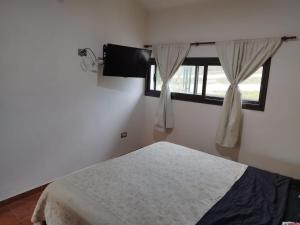 a bedroom with a bed and a window at Estancia Borke - Carlos Paz in Estancia Vieja