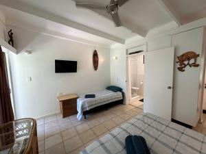 um quarto com uma cama e uma televisão na parede em Magnetic Island Resort Studio em Nelly Bay