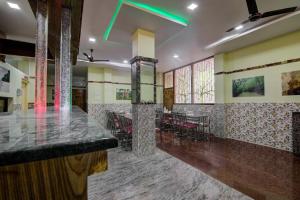 een bar in een restaurant met tafels en stoelen bij OYO Flagship 14426 V Knot Residency in Garacherāma