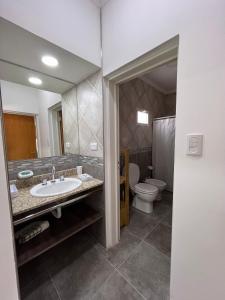 a bathroom with a sink and a toilet at Atuel Alojamiento in San Antonio Oeste +14 photos