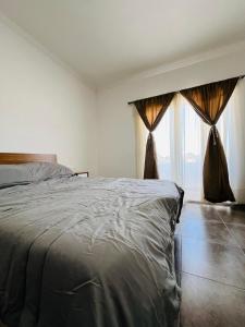 a bedroom with a bed and a large window at Atuel Alojamiento in San Antonio Oeste