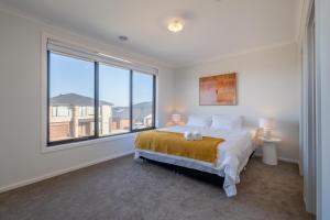a bedroom with a bed and a large window at Modern new Homly House at Clyde in Clyde