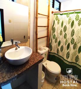 a bathroom with a sink and a toilet and a shower curtain at Costa Verde Hostal in Manta