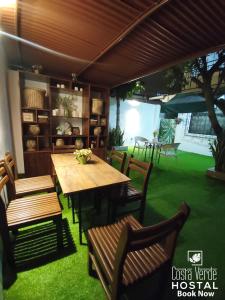 a dining room with a wooden table and chairs at Costa Verde Hostal in Manta