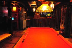 a red pool table in a room with a light at Hotel Pousada Katmandu in Maresias