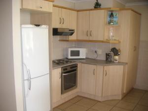 una cucina con frigorifero bianco e forno a microonde di WatersideLiving MS11 a Jeffreys Bay
