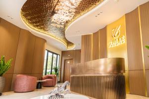 un vestíbulo de un hotel con un gran techo dorado en Hotel Trí Lê PREMIER, en Cao Lãnh