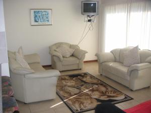 Una sala de estar con dos sillas y un televisor. en WatersideLiving MS11, en Jeffreys Bay