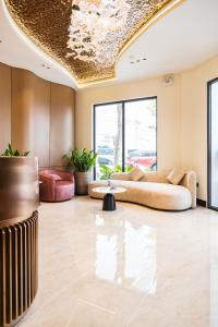 Hotel Trí Lê PREMIER في Cao Lãnh: غرفة معيشة مع أريكة وطاولة