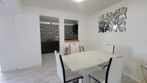 una sala da pranzo bianca con tavolo e sedie bianchi di Maison d'Hanaya a Le Marin