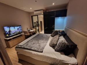 a bedroom with a large bed and a flat screen tv at Once Pattaya Seaview Condo in Pattaya Central