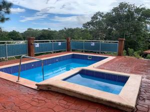 a swimming pool on top of a brick patio at Villa Arcoíris de la Montaña in Jarabacoa