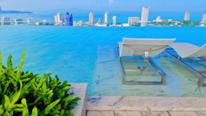 a chair sitting on the edge of a swimming pool at Once Pattaya Seaview Condo in Pattaya Central