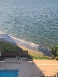 a view of a beach with a bench and the ocean at Bayfront in Portmore