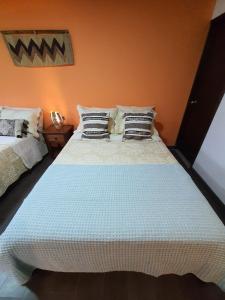een slaapkamer met een groot wit bed met kussens bij Hospedaje rural - Finca la Aurora - Caqueza in Cáqueza