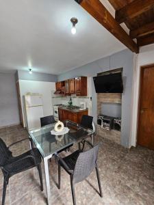 Alojamiento Ado في سيوداد لوجان دي كويو: غرفة معيشة مع طاولة وكراسي ومطبخ