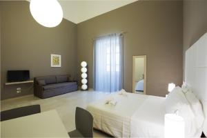 
a hotel room with a bed and a television at Central Gallery Rooms- Palazzo D'Ali' Staiti XIX in Trapani
