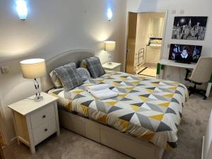 a bedroom with a bed and a table with a tv at Entire Apartment - Excel Exhibition Centre O2 Arena London Royal Victoria Canning Town in London