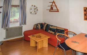 Rinnにある2 Bedroom Gorgeous Apartment In Rinn B, Innsbruckのリビングルーム(赤いソファ、テーブル付)