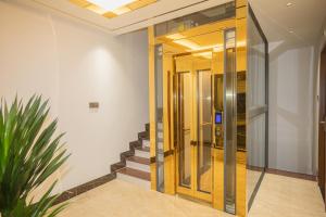 un pasillo con escaleras y un ascensor de cristal en Hotel Trí Lê PREMIER en Cao Lãnh