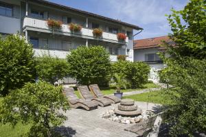 einen Innenhof mit Liegestühlen und einem Brunnen vor einem Gebäude in der Unterkunft Wellness Ferienwohnung Schweinsteiger mit Hallenbad und Sauna in Oberaudorf