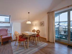 a dining room with a table and chairs and a balcony at Wellness Ferienwohnung Schweinsteiger mit Hallenbad und Sauna in Oberaudorf