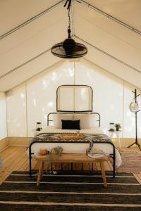 a bedroom with a bed and a wooden table at Luxury Glamping Tents @ Lake Guntersville State Park in Guntersville