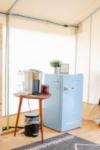 a blue refrigerator next to a table with a blender at Luxury Glamping Tents @ Lake Guntersville State Park in Guntersville