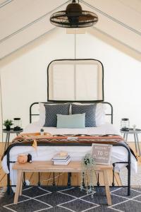 a bedroom with a bed and a table with books at Luxury Glamping Tents @ Lake Guntersville State Park in Guntersville