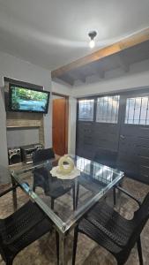 ein Wohnzimmer mit einem Glastisch und 2 Stühlen in der Unterkunft Alojamiento Ado in Ciudad Lujan de Cuyo