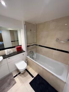 a bathroom with a toilet and a tub and a sink at Entire Apartment - Excel Exhibition Centre O2 Arena London Royal Victoria Canning Town in London