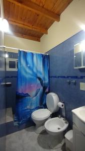 a bathroom with a toilet and a shower curtain at Departamento in Puerto Madryn