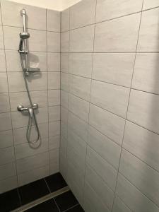 y baño con ducha de azulejos blancos. en Gasthof Lublass en Matrei in Osttirol