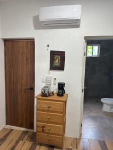 a room with a wooden dresser and a toilet at Haciendita Xul-Ha in Xul-Ha