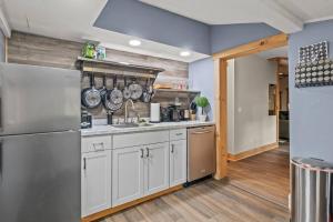 a kitchen with white cabinets and a stainless steel refrigerator at Cozy Home W/ King Bed & Lake access in Canandaigua