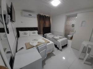 a small room with two beds and a toilet at HOTEL CENTRAL MARGARITA in Boa Vista +25 photos
