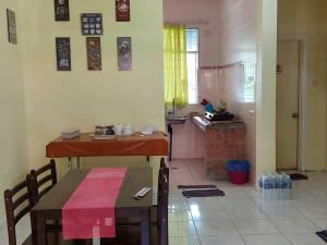 a living room with a table and a kitchen at Samma HomeStay Double Storey Terrace House in Kota Kinabalu