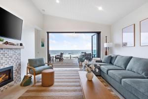 a living room with a couch and a fireplace at Beachfront Luxury Suite #19 at THE BEACH HOUSE in Campbell River
