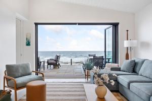 a living room with a view of the ocean at Beachfront Luxury Suite #19 at THE BEACH HOUSE in Campbell River