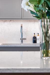 um lavatório de cozinha com uma torneira e duas garrafas de sabão em Beachfront Luxury Suite #19 at THE BEACH HOUSE em Campbell River