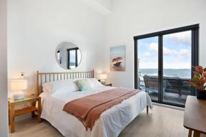 um quarto com uma cama e vista para o oceano em Beachfront Luxury Suite #19 at THE BEACH HOUSE em Campbell River