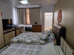 サン・ガブリエウにあるCasa e Ateliê de pintura Neiva Marioのベッドルーム(ベッド2台、テレビ付)