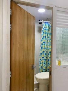 a bathroom with a toilet and a wooden door at Hostel Bogotá Kings in Bogotá +51 photos