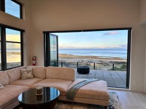a living room with a couch and a view of the ocean at Saratoga Serenity at THE BEACH HOUSE in Campbell River