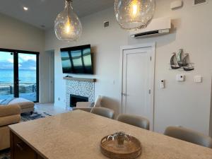uma cozinha e sala de estar com uma mesa e uma lareira em Saratoga Serenity at THE BEACH HOUSE em Campbell River