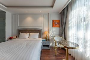 a bedroom with a bed and a glass table at Golden Star Apartment & Hotel in Ho Chi Minh City
