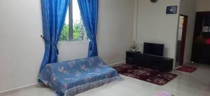 uma sala de estar com um sofá azul e uma janela em Homestay Kg Paya D Jitra em Jitra