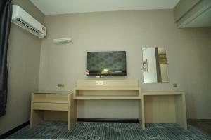 a room with a tv on a wall at Regent Hotel in Keningau