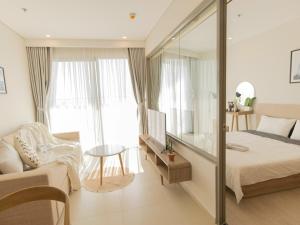 1 dormitorio con 1 cama y pared de cristal en The Song Vita's Apartment, en Vung Tau