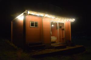 une petite maison éclairée la nuit dans l'établissement Refugio Aventura, hermosa cabaña y acogedores glampings en Tabio, cerca a Bogotá, à Tabio